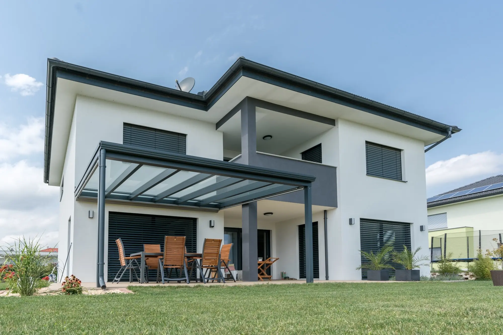 Beispiel einer moderne Aluminium Terrassenüberdachung mit Glasdach am Einfamilienhaus